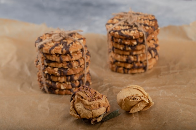 Pilha de biscoitos de aveia com cobertura de chocolate colocados na mesa de pedra.