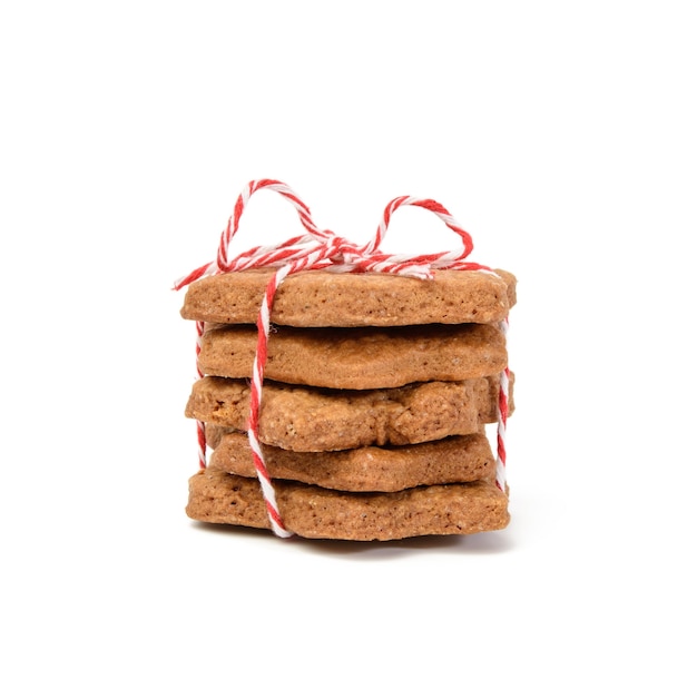 Pilha de biscoitos de chocolate assados em forma de estrela amarrados com corda vermelha e isolados no fundo branco