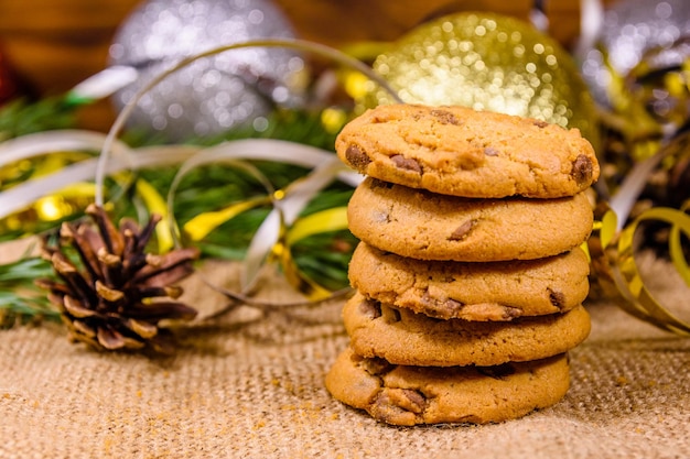 Pilha de biscoitos de chocolate no saco na frente das decorações de Natal