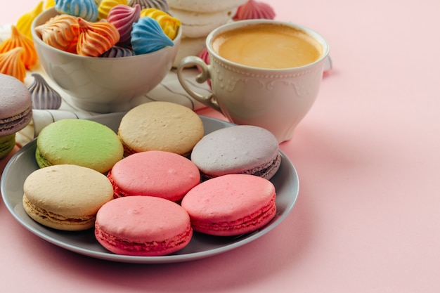 Pilha de biscoitos de macaroon coloridos com café