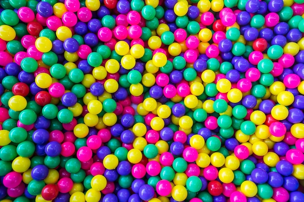 Fundo de muitas bolas coloridas de plástico na piscina de bolas em