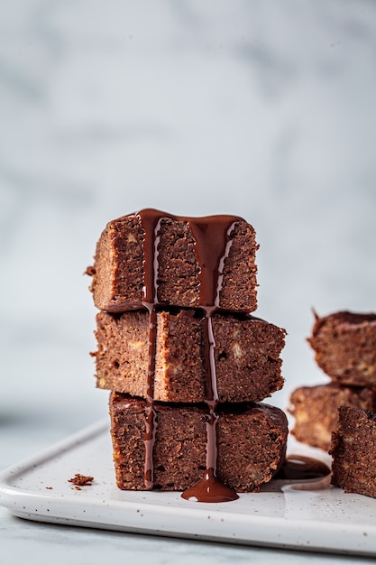 Pilha de brownies veganos com chocolate amargo em um quadro branco