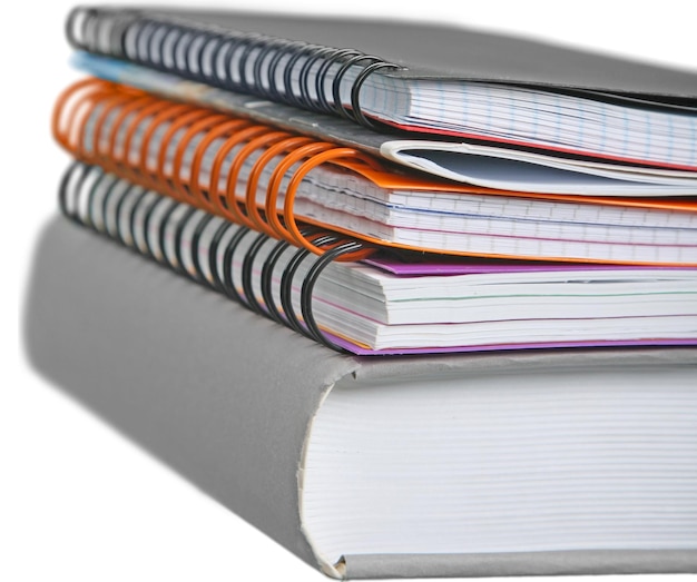Pilha de cadernos com livro isolado no branco