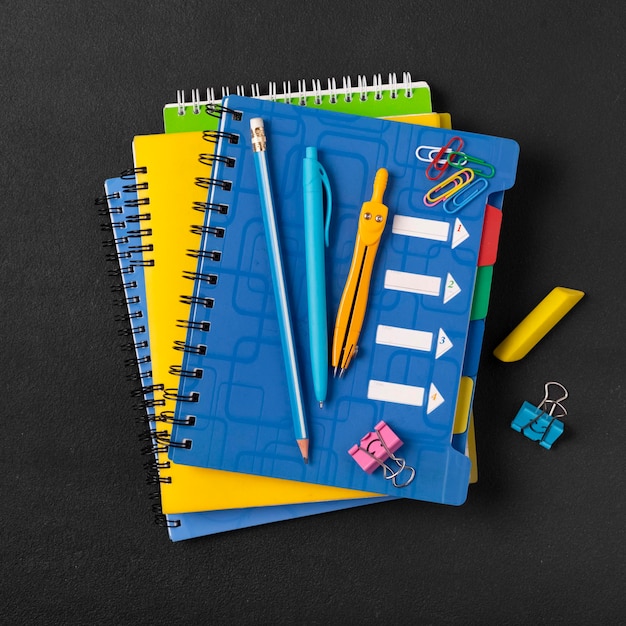 Pilha de cadernos escolares coloridos e um despertador