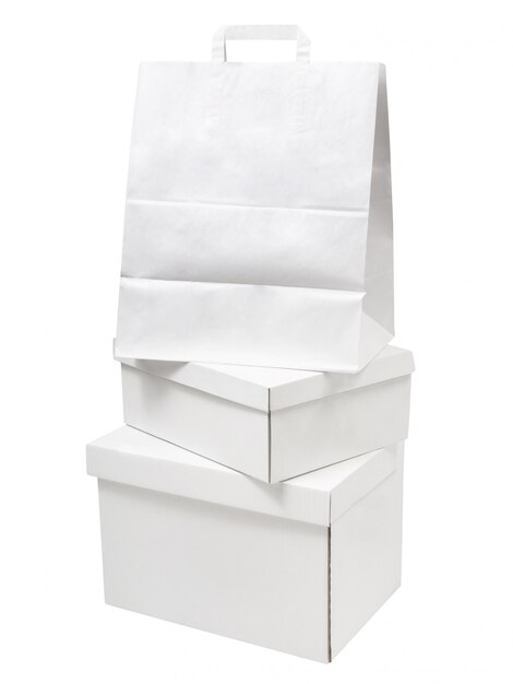 Pilha de caixas de papel branco em branco e pacotes de saco de papel isolados no fundo branco