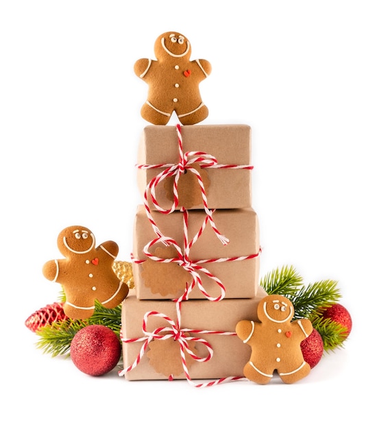Pilha de caixas de presentes de Natal em papel artesanal com biscoitos crocantes de homens de gengibre e decoração brilhante. Conceito de feliz natal em fundo branco