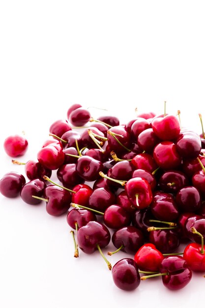 Pilha de cerejas frescas em um fundo branco.