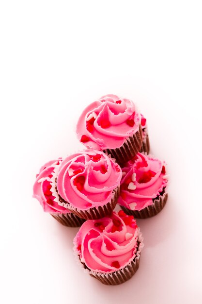 Pilha de cupcakes rosa com anel de noivado no topo.