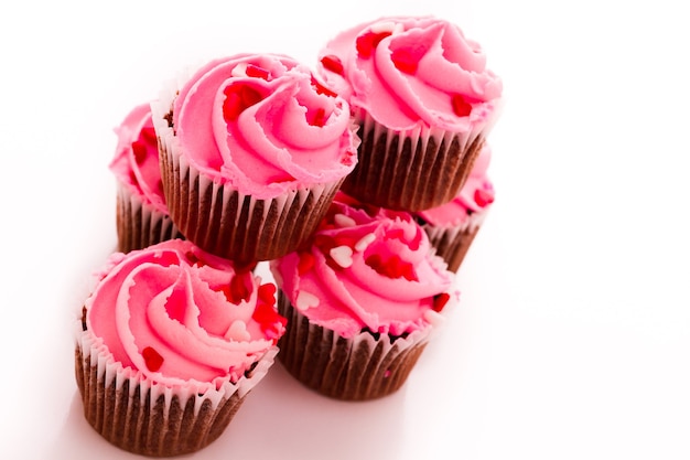 Pilha de cupcakes rosa com anel de noivado no topo.