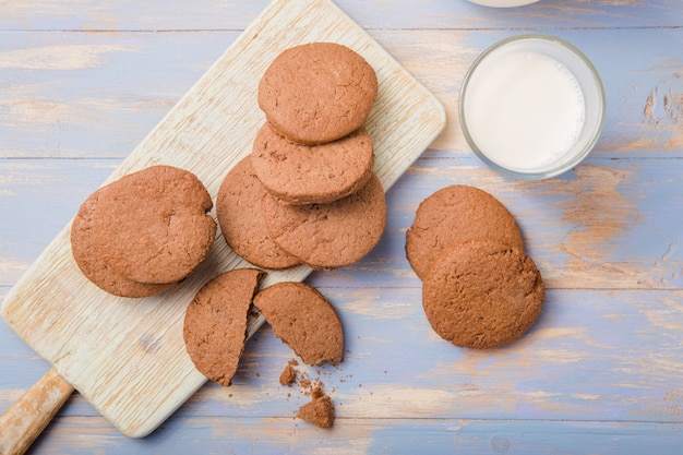 Pilha de deliciosos biscoitos de chocolate em uma placa com garrafas de leite