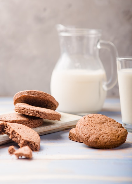 Pilha de deliciosos biscoitos de chocolate em uma placa com garrafas de leite