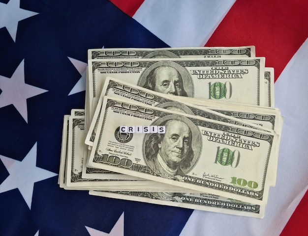 Pilha de dinheiro na bandeira americana e texto crise financeira dólar inflação recessão economia global