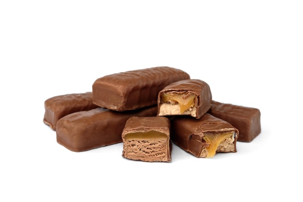 Pilha de doces de chocolate com nougat, caramelo e nozes, isolados no fundo branco.