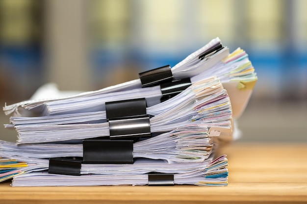 Pilha de documentos de arquivos de papéis alcança com clipes no trabalho no escritório