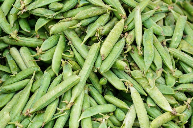 Pilha de ervilhas verdes frescas exibidas no mercado de comida de rua