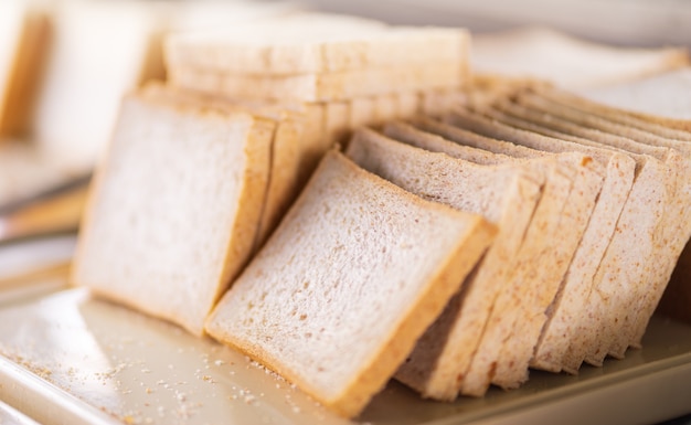 Pilha de fatias de pão branco na bandeja na linha de buffet do hotel