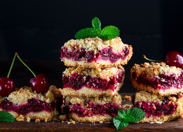 Pilha de fatias quadradas de uma torta com uma cereja