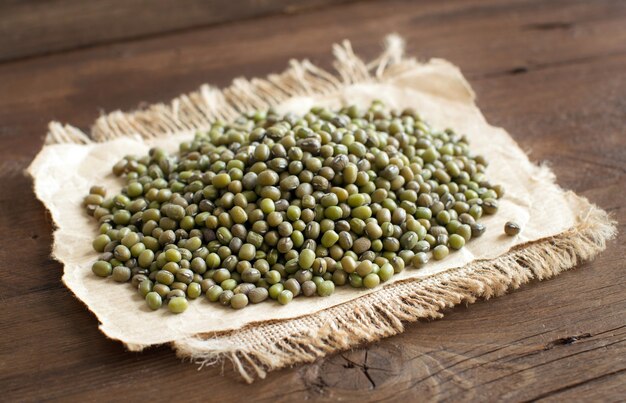 Pilha de feijão mungo cru em uma mesa de madeira