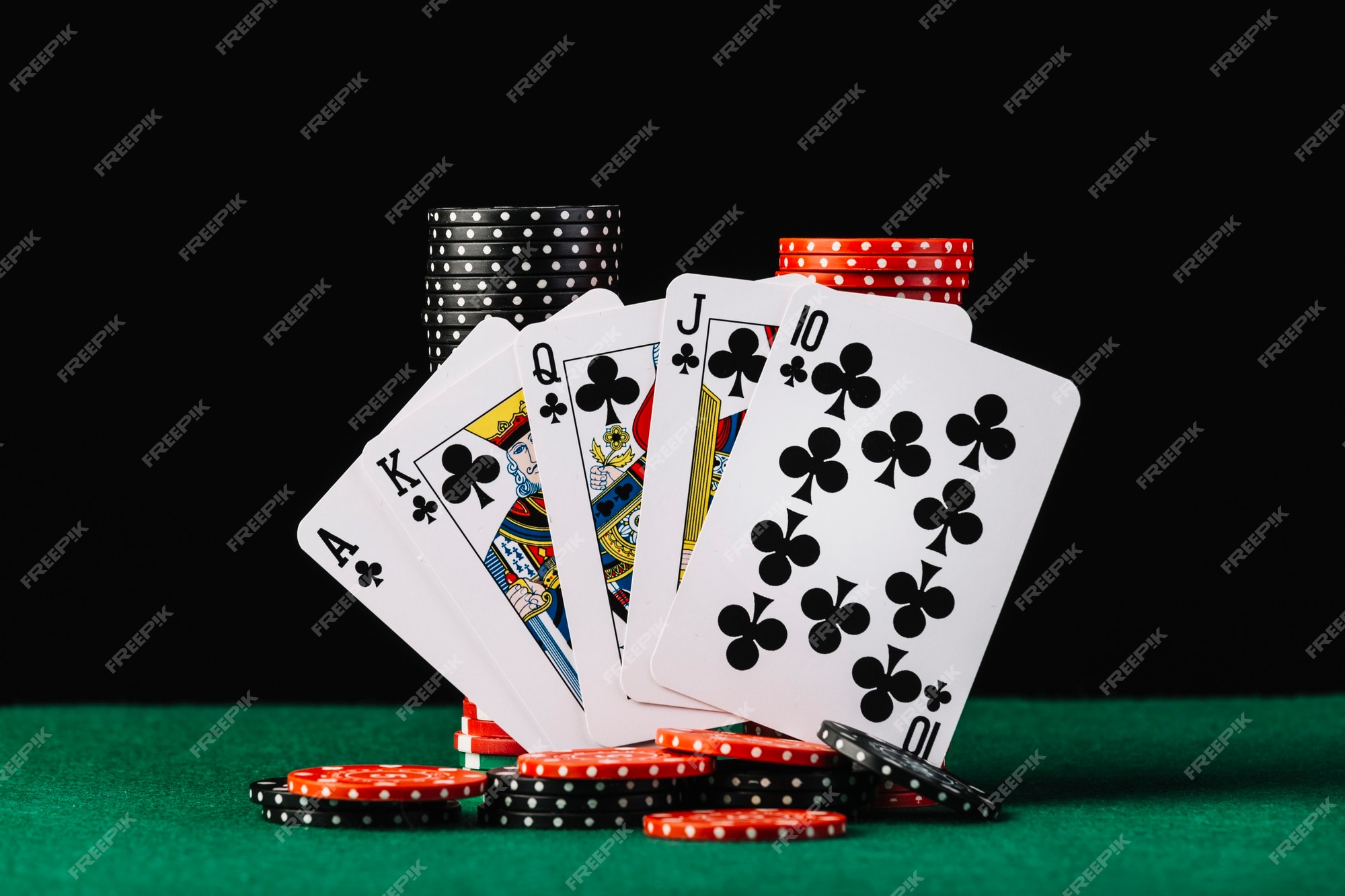 Pilha de fichas de cassino e royal flush baralho na mesa de poker verde