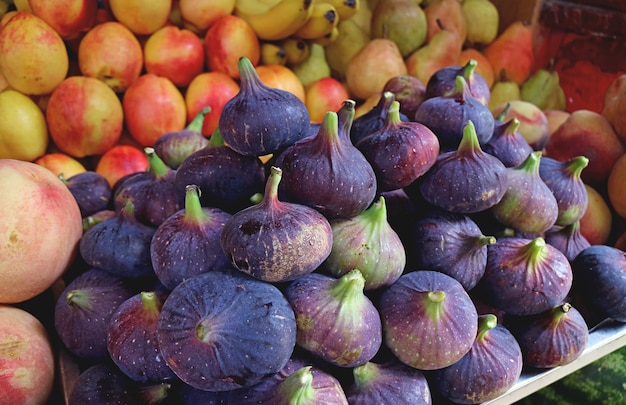 Pilha de figos maduros frescos de cor roxa escura à venda no mercado