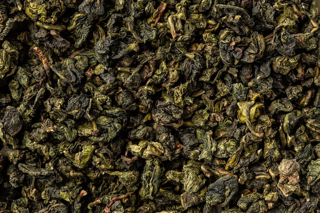 Pilha de folhas de chá secas. Chá verde seco. Plano de fundo texturizado de folhas secas de chá aromático.