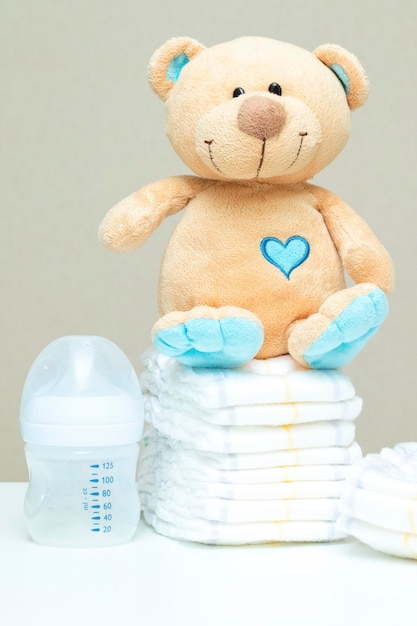 Pilha de fraldas com ursinho de pelúcia e garrafa de leite. definido para menino menina para chá de bebê, copie o espaço