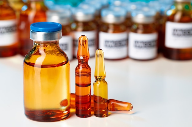 Pilha de frascos de vidro com medicação na mesa do laboratório close-up