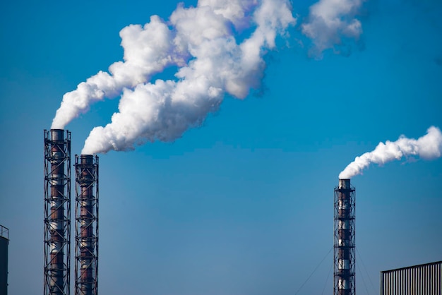 Pilha de fumaça da usina de carvão no fundo do céu azul. Lugar para texto