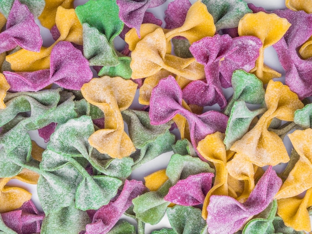 Pilha de fundo de massa italiana Tri Color Farfalle seca Várias cores de gravata borboleta