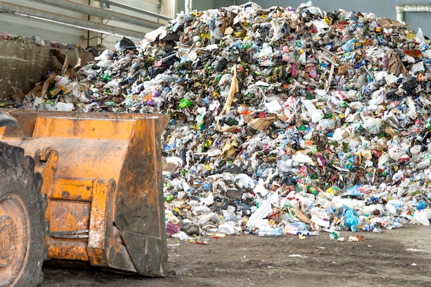 Foto pilha de garrafas plásticas, papel e polietileno em uma planta de reciclagem de resíduos antes de selecionar