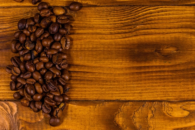 Pilha de grãos de café na mesa de madeira rústica. Vista do topo