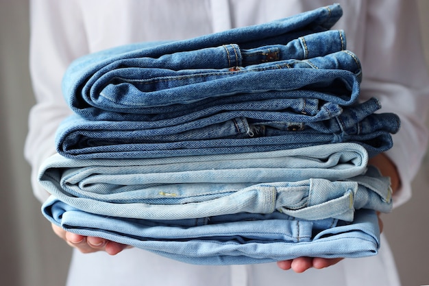 Pilha de jeans dobrados nas mãos do homem