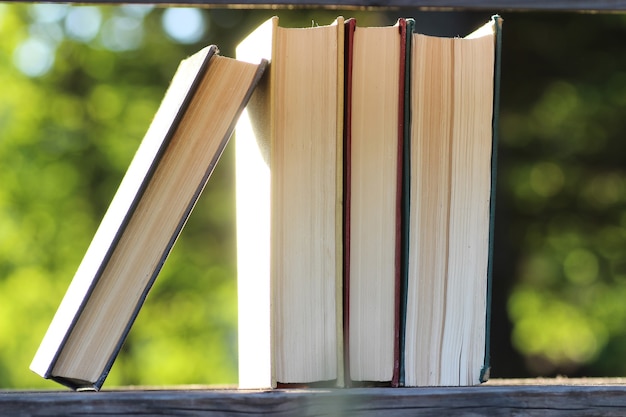 Pilha de livros com fundo de mesa de madeira ao ar livre