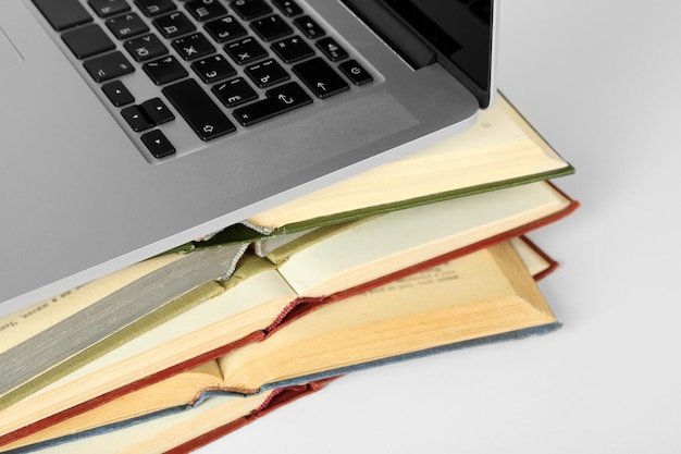 Pilha de livros com laptop de perto
