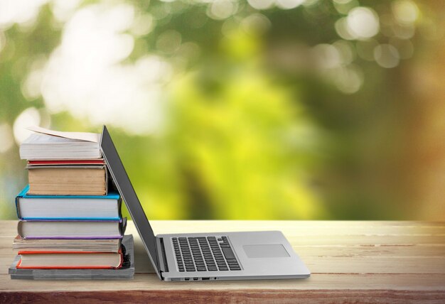 Pilha de livros com laptop na mesa