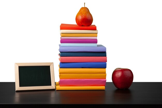 Pilha de livros e maçã na mesa contra um fundo branco