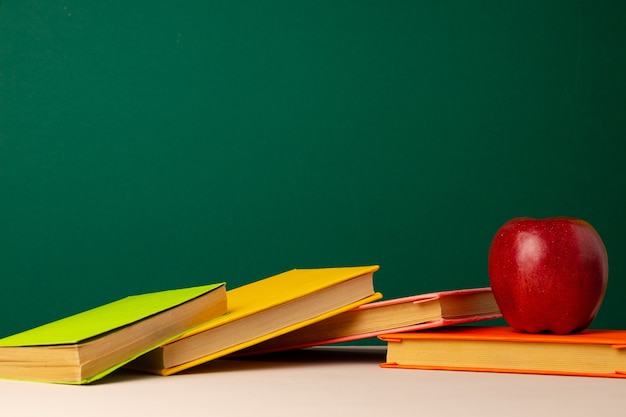 Pilha de livros e maçã vermelha na mesa. Conceito de volta às aulas