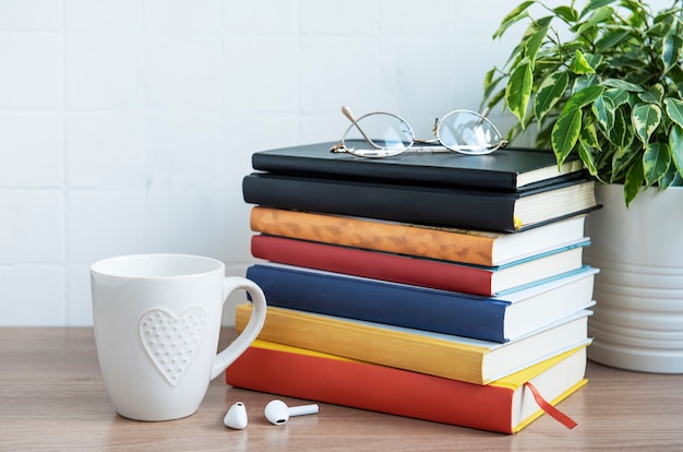 Pilha de livros na área de trabalho. Vários livros e material de escritório sobre a mesa