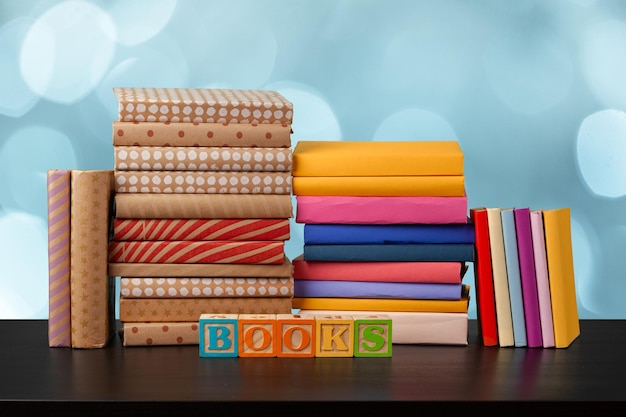 Pilha de livros na mesa de madeira contra o fundo desfocado