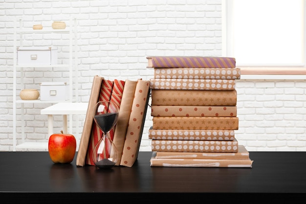 Pilha de livros na mesa de madeira contra o fundo desfocado