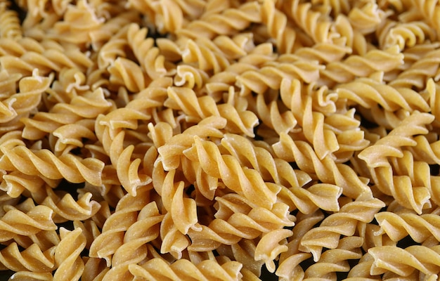 Pilha de macarrão Fusilli de trigo integral cru para o conceito de bem-estar