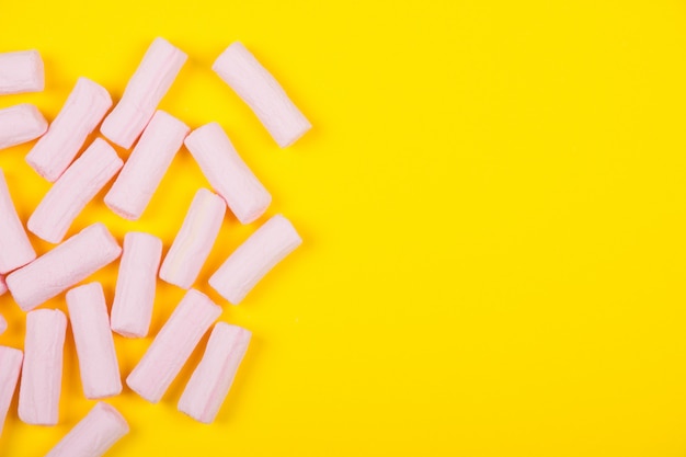 Pilha de marshmallows rosa em um fundo amarelo