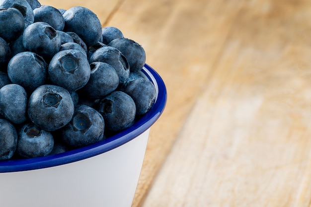 Pilha de mirtilos na tigela sobre fundo de frutas frescas de mesa