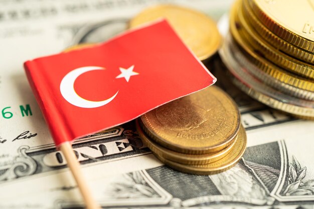 Pilha de moedas com bandeira da Turquia e notas de dólar americano