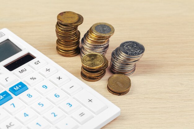 Pilha de moedas e calculadora, ideia de conceito para finanças empresariais
