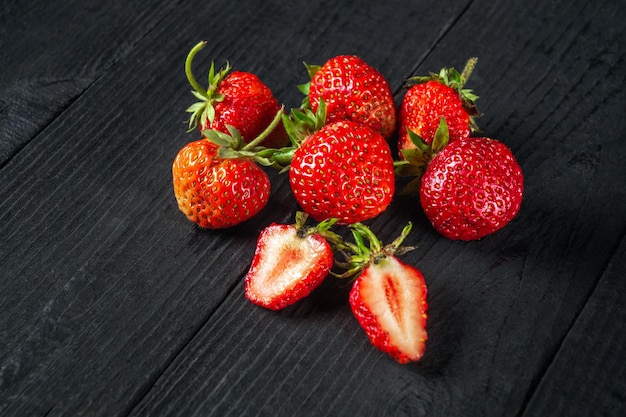 Pilha de morangos frescos em uma mesa preta vintage. Ideia de dieta de verão para kit de vitaminas