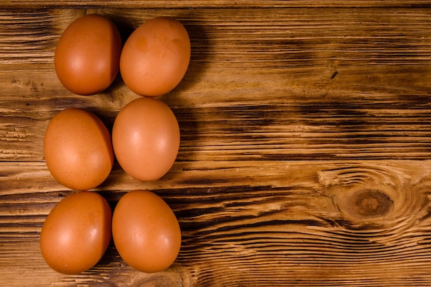 Pilha de ovos de galinha na mesa de madeira rústica. Vista do topo