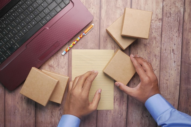 Pilha de pacotes de papelão e laptop na mesa