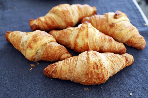 Pilha de padaria de deliciosos croissants na toalha de mesa