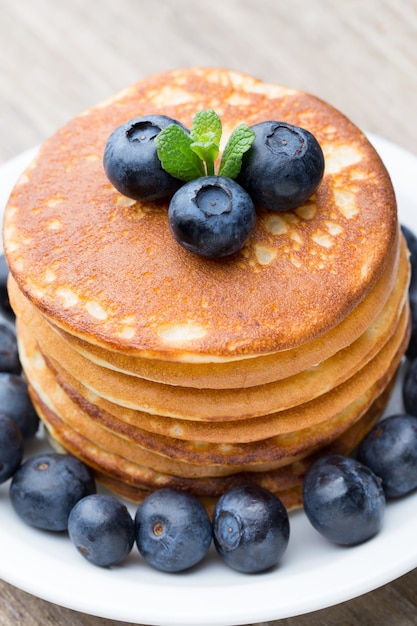 Pilha de panquecas com mirtilo e frutas frescas.